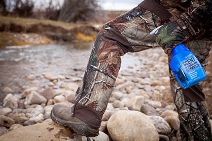 Hunter Spraying Code Blue on Hunting Pants 