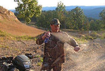 Man Using Scent Spray in the Woods